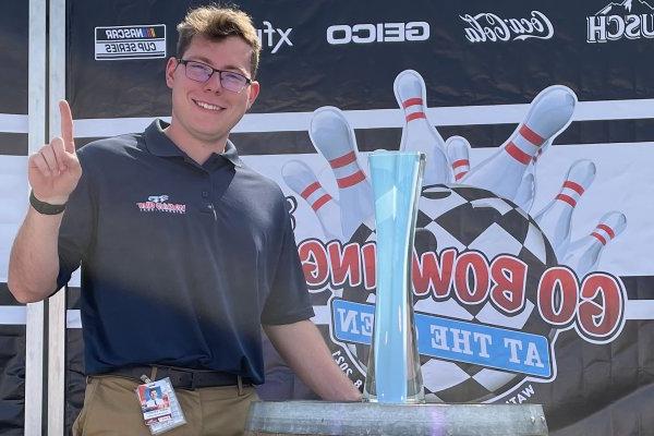 Robert Stevens '22 stands next to trophy at Watkins Glen international racetrack.